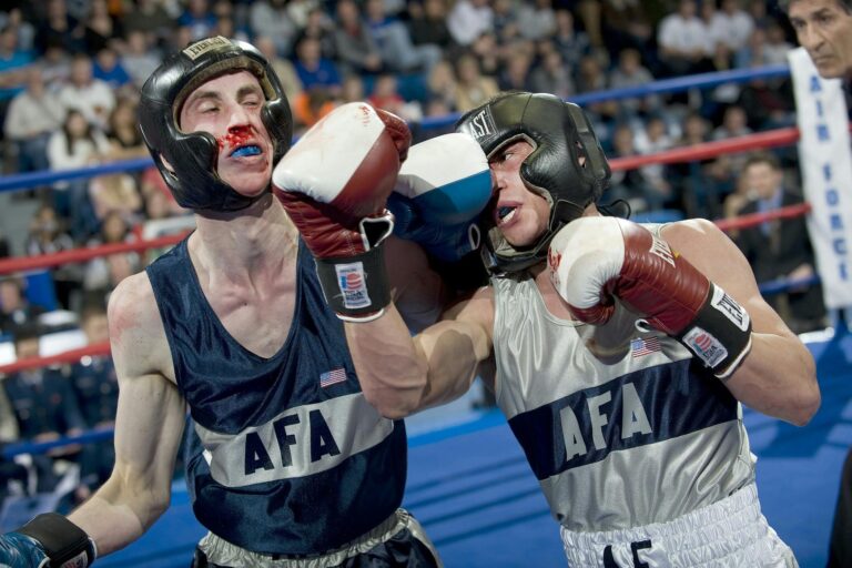 Two boxers in a heated match deliver powerful punches in the ring.